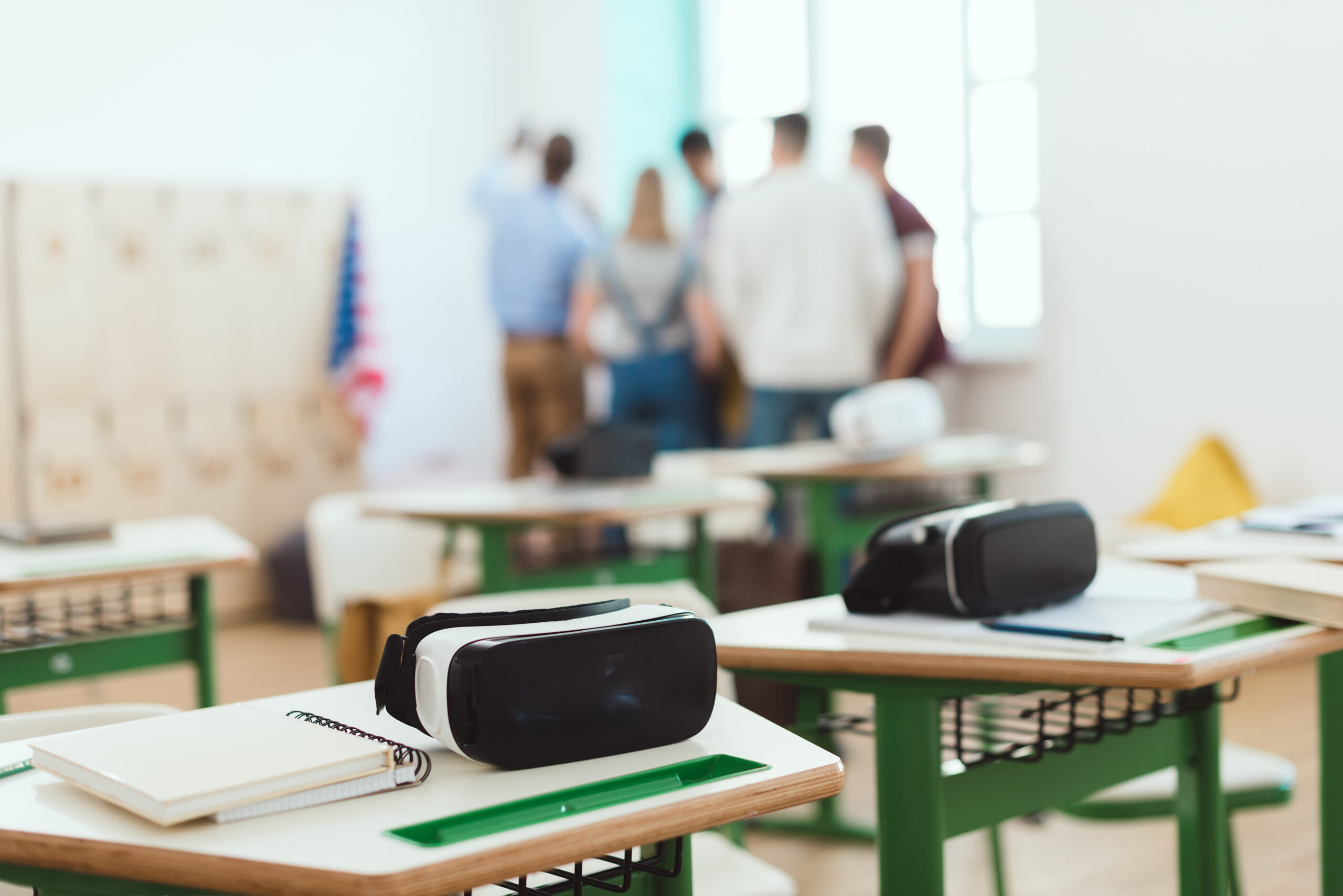 Visores de realidad virtual colocados sobre pupitres en un aula, preparados para una actividad educativa inmersiva.
