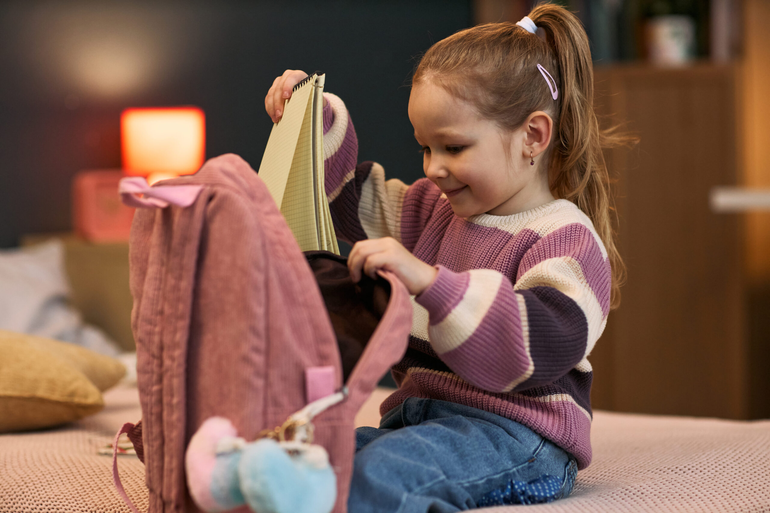 Niña preparando su mochila como parte de las rutinas diarias para niños antes del colegio