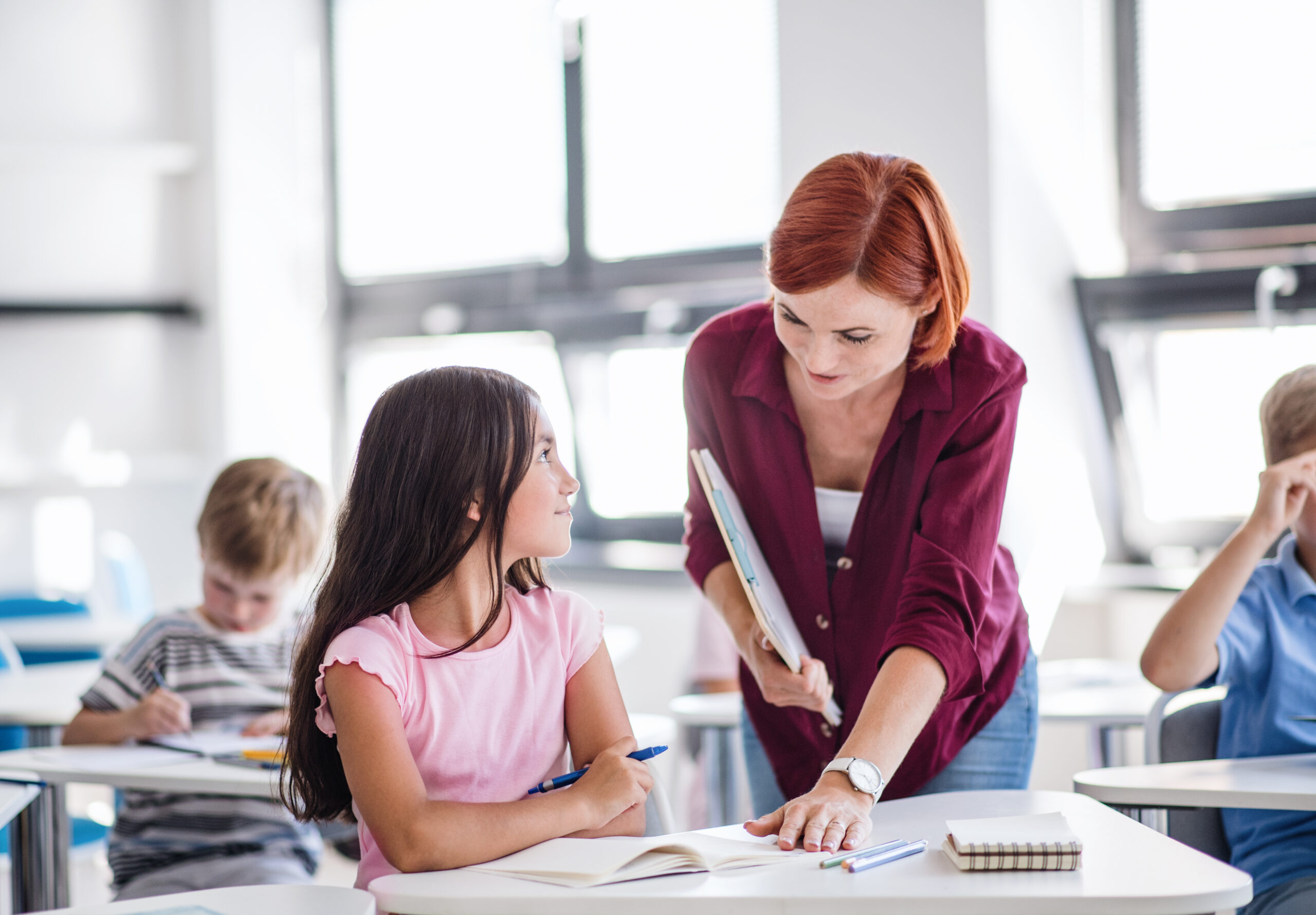 Docente evaluando el trabajo de alumnos dentro del modelo de evaluación por competencias según la LOMLOE