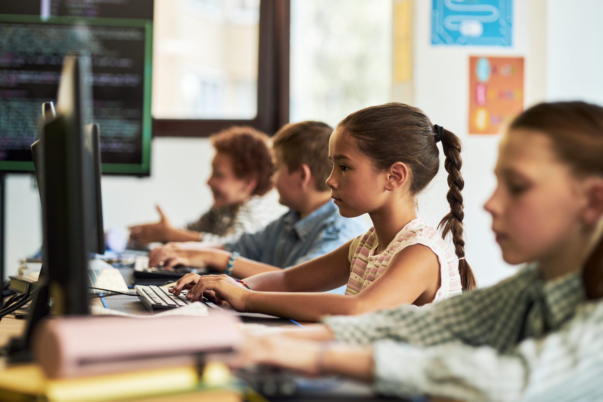 Alumnos utilizando ordenadores en un aula para aprender con herramientas digitales